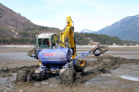 Equipped with swamp pads, the spider works through silt to bury breakwater anchors.